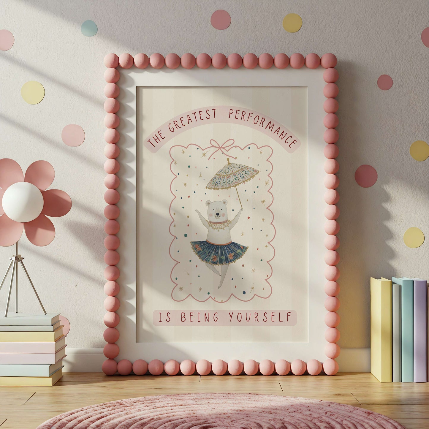 Framed artwork with a bear illustration and motivational quote in a room with polka dot wallpaper.