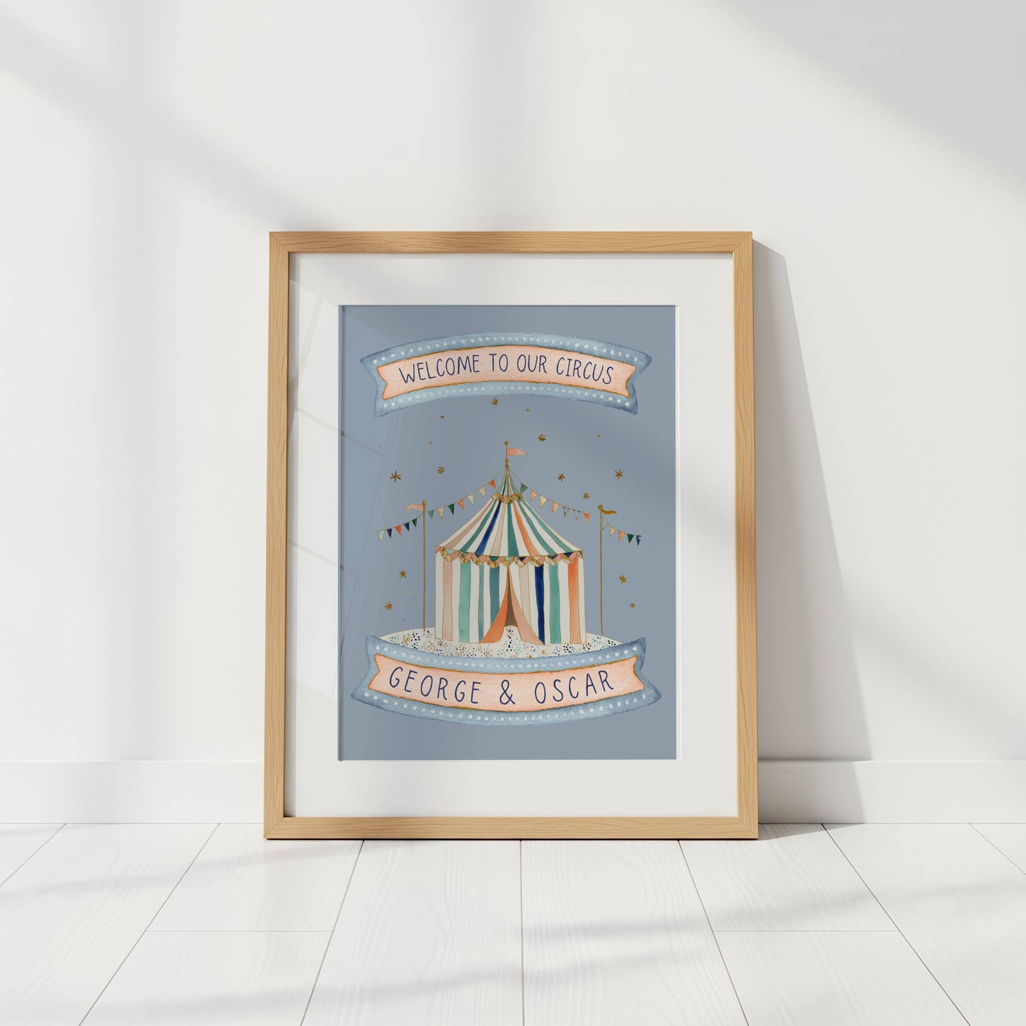 Framed artwork of a circus tent with 'Welcome to our circus' and 'George & Oscar' text on a light background.