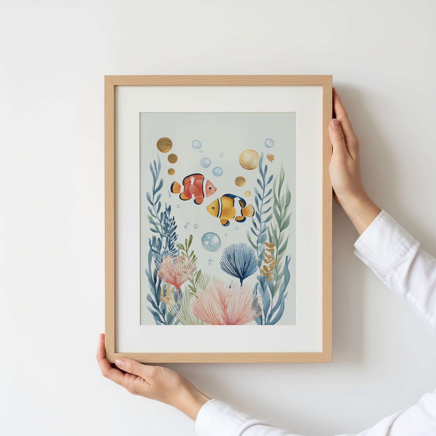 Framed artwork of underwater scene with fish and plants held by a person.
