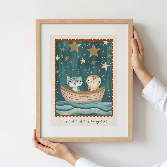 Framed artwork of an owl and cat in a boat under stars, held by a person.